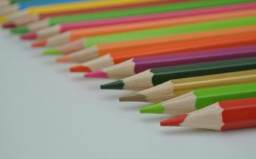 Close-up image of vibrant colored pencils arranged in a row.